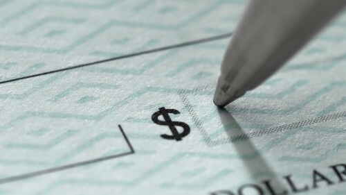 Closeup of pen writing on a blank bank check